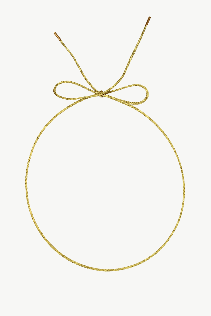 A delicate gold chain necklace arranged in a large oval with a bow at the top, shown against a plain white background.