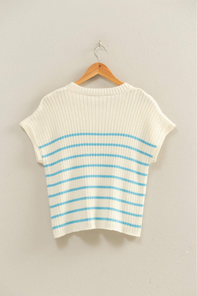 White and blue striped sweater on a wooden hanger against a light gray background