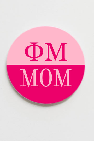 Pink and white circular sticker with 'ΦM MOM' text on a light gray background