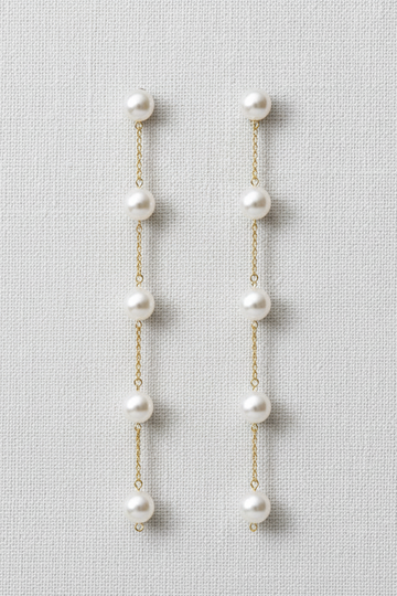 Pair of pearl earrings on a light gray background