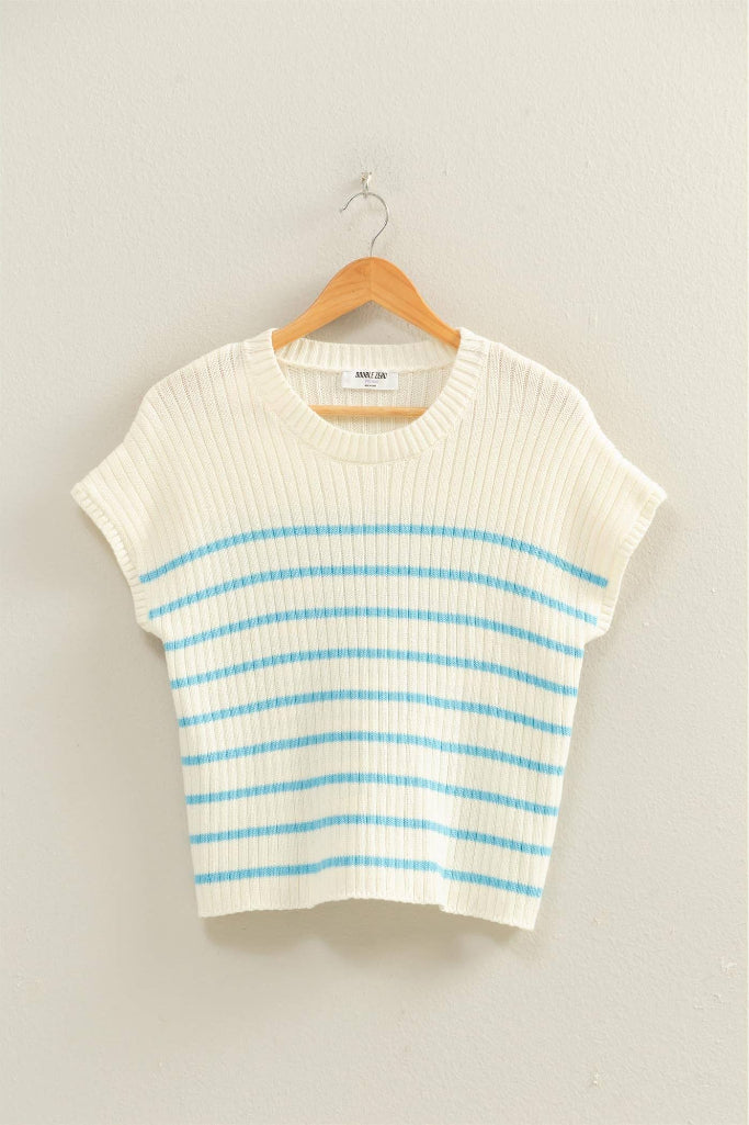 White and blue striped sweater on a hanger against a light gray background