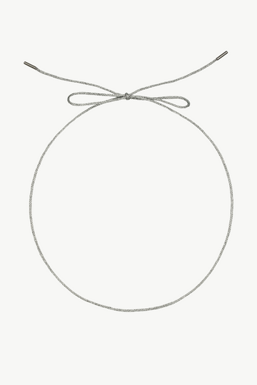 A silver-toned rope necklace with a knotted top and a small metal clasp at the end, displayed on a clean off-white background.