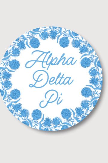 Circular Alpha Delta Pi logo with blue floral design on a white background