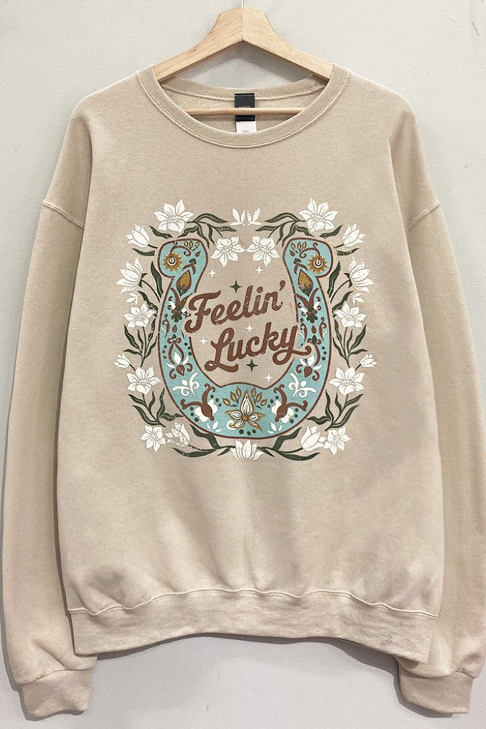 Front of taupe crewneck sweatshirt with floral Feelin' Lucky horseshoe graphic