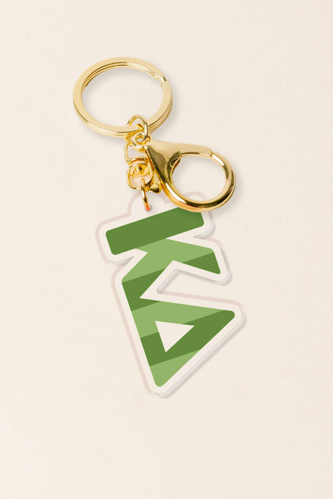Keychain with green geometric design on a beige background