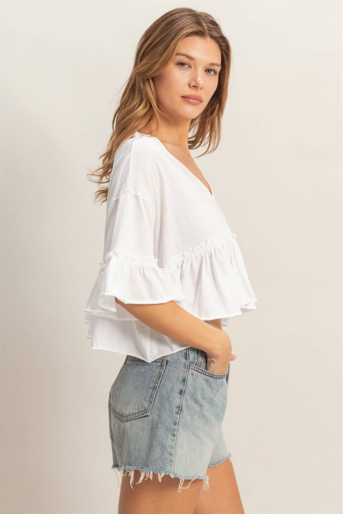Woman wearing a white blouse and denim shorts on a plain background