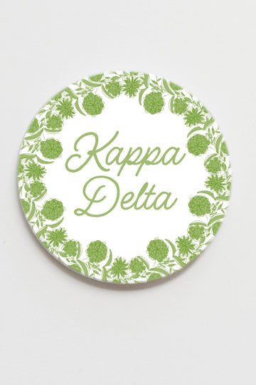 Circular coaster with green floral pattern and 'Kappa Delta' text on a white background