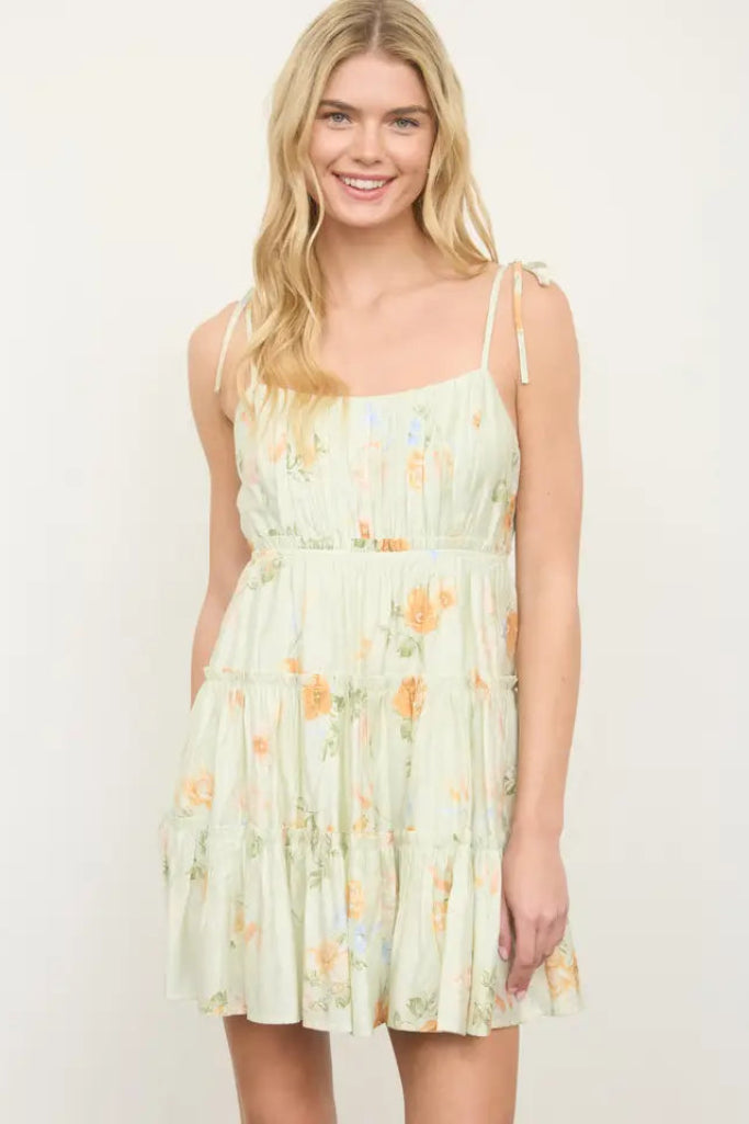 Woman wearing a light green floral dress against a white background