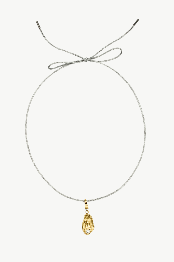 A delicate silver-toned rope necklace with a small gold teardrop pendant, displayed on a clean off-white background.