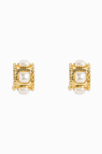 Gold earrings with pearl-like centers on a white background