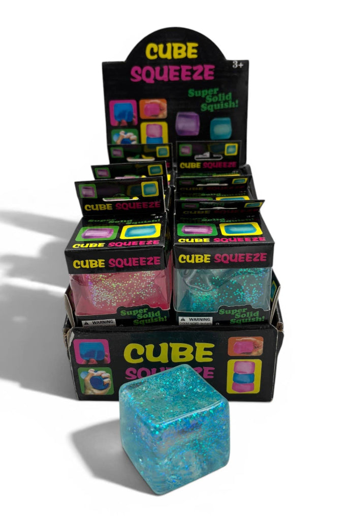 Display of Cube Squeeze toys with a blue glittery cube in front.