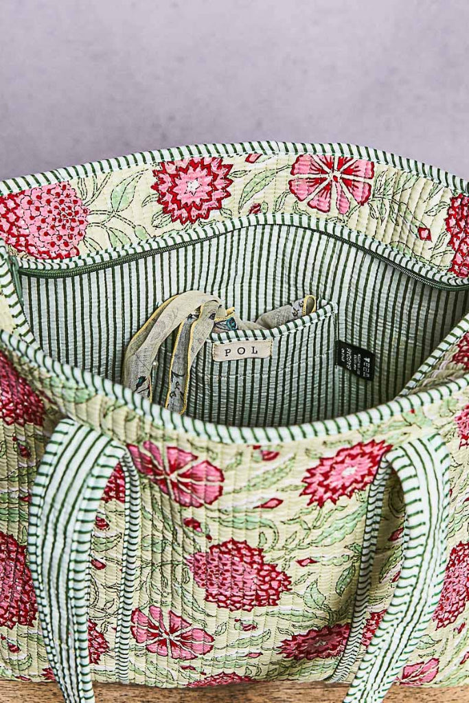 Floral-patterned bag with striped lining on a gray background