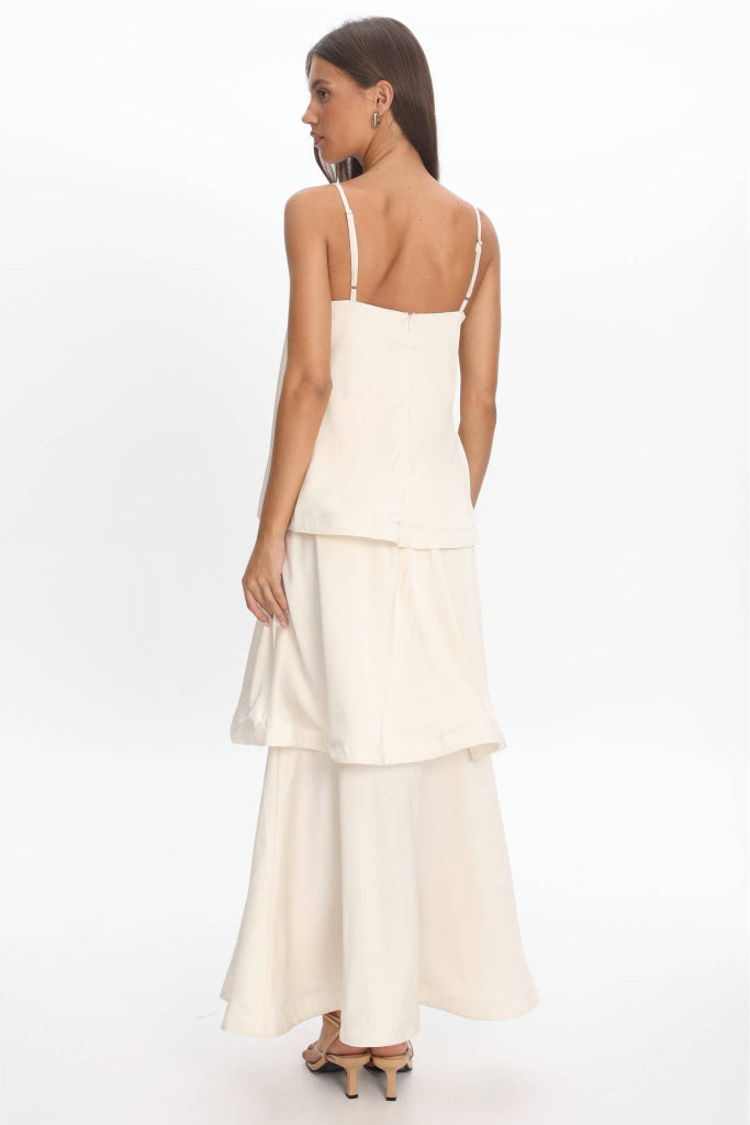 Woman wearing a white dress with thin straps on a white background