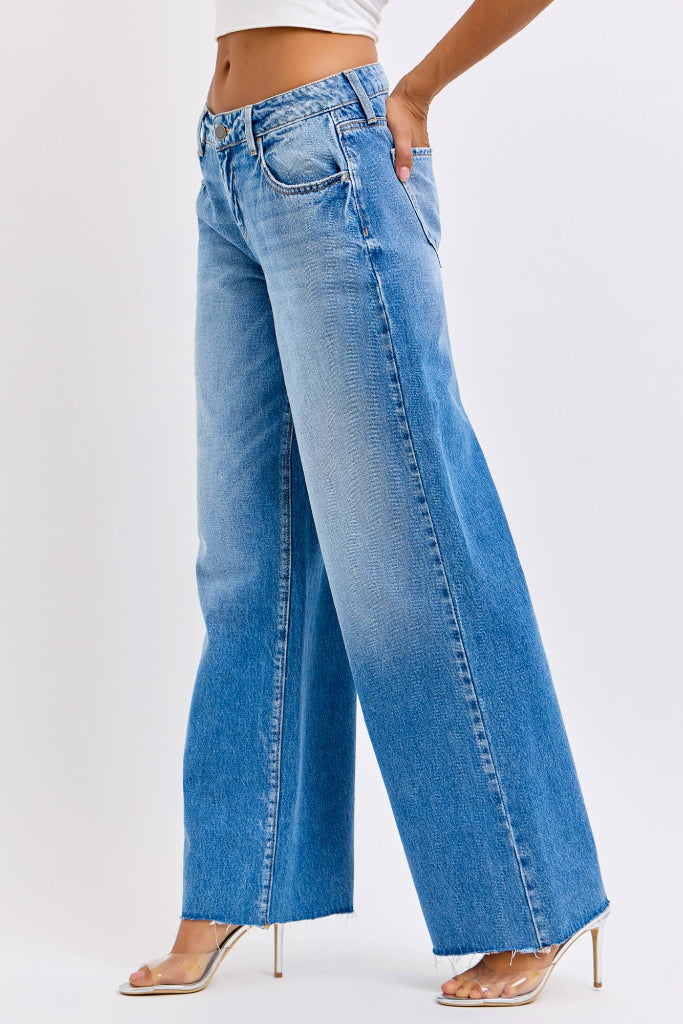 Blue wide-leg jeans worn by a person on a white background