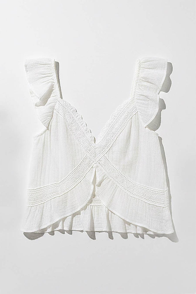 White lace top with ruffled details on a white background