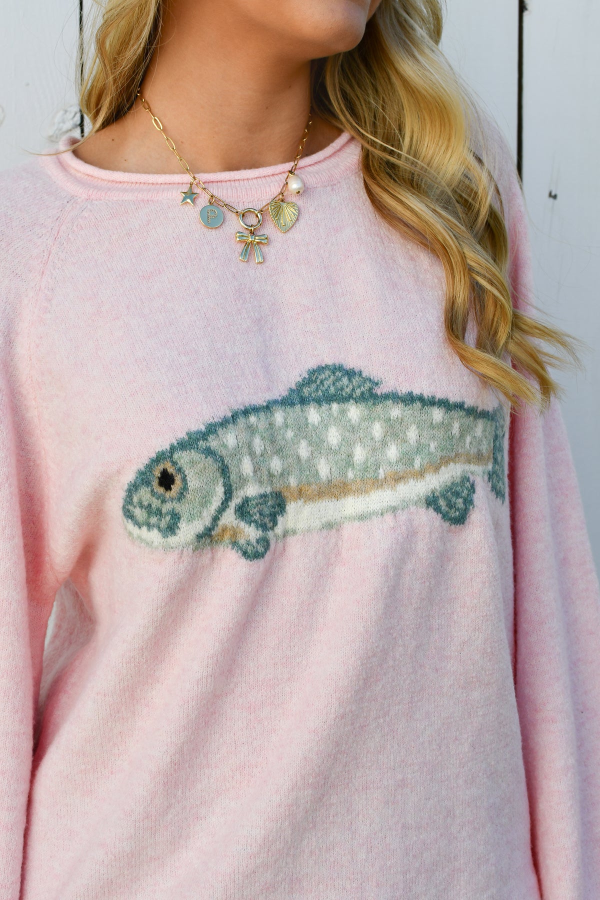 Close-up of trout fish knit design on pink sweater