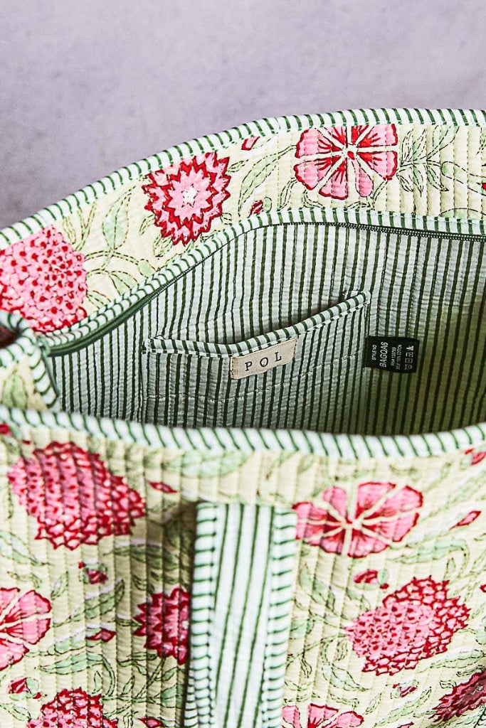 Floral-patterned fabric with visible brand labels on a gray background