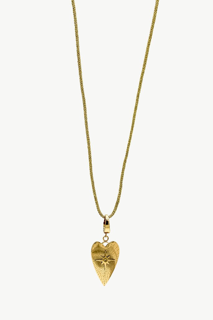 A gold heart-shaped pendant necklace with a textured surface and a small star detail, suspended on a delicate gold chain against a light off-white background.