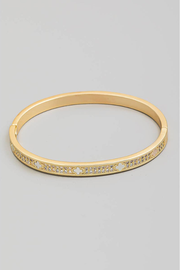 Gold bracelet with small stones on a gray background