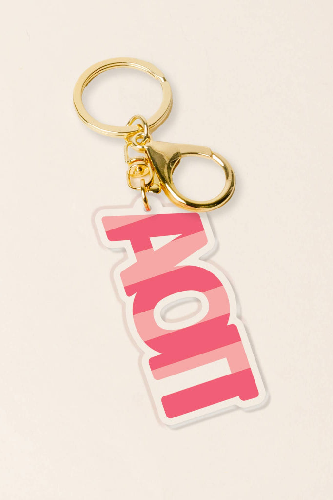 Keychain with pink and white design on a beige background