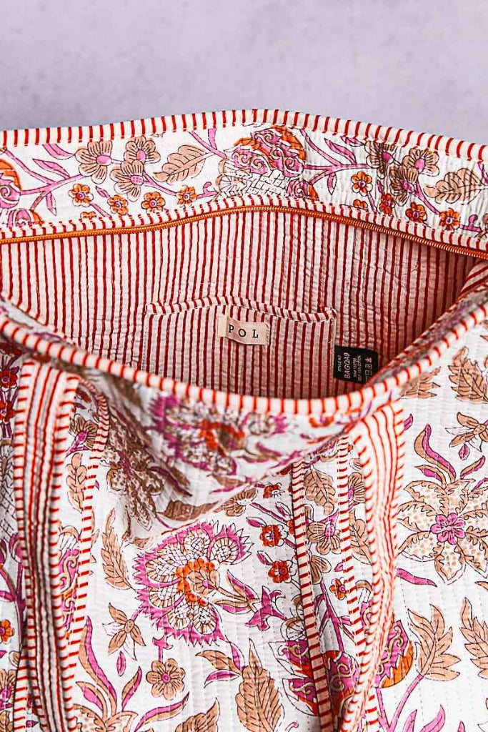 Close-up of a patterned shirt with visible brand label on a light purple background