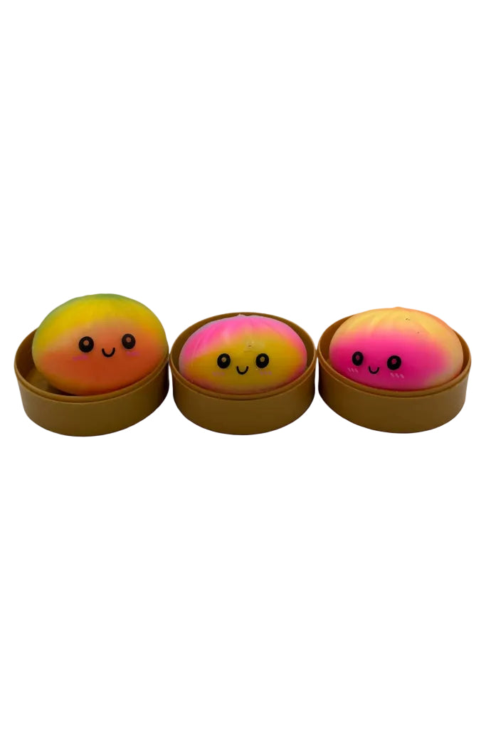 Three colorful spherical treats with smiling faces in brown containers on a white background