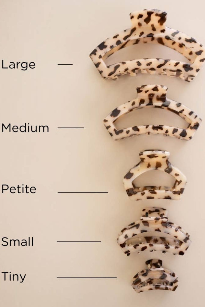Five claw hair clips in different sizes are arranged vertically on a light beige background, each with a black and cream leopard print. Text labels 'Large', 'Medium', 'Petite', 'Small', and 'Tiny' with lines pointing to each size.